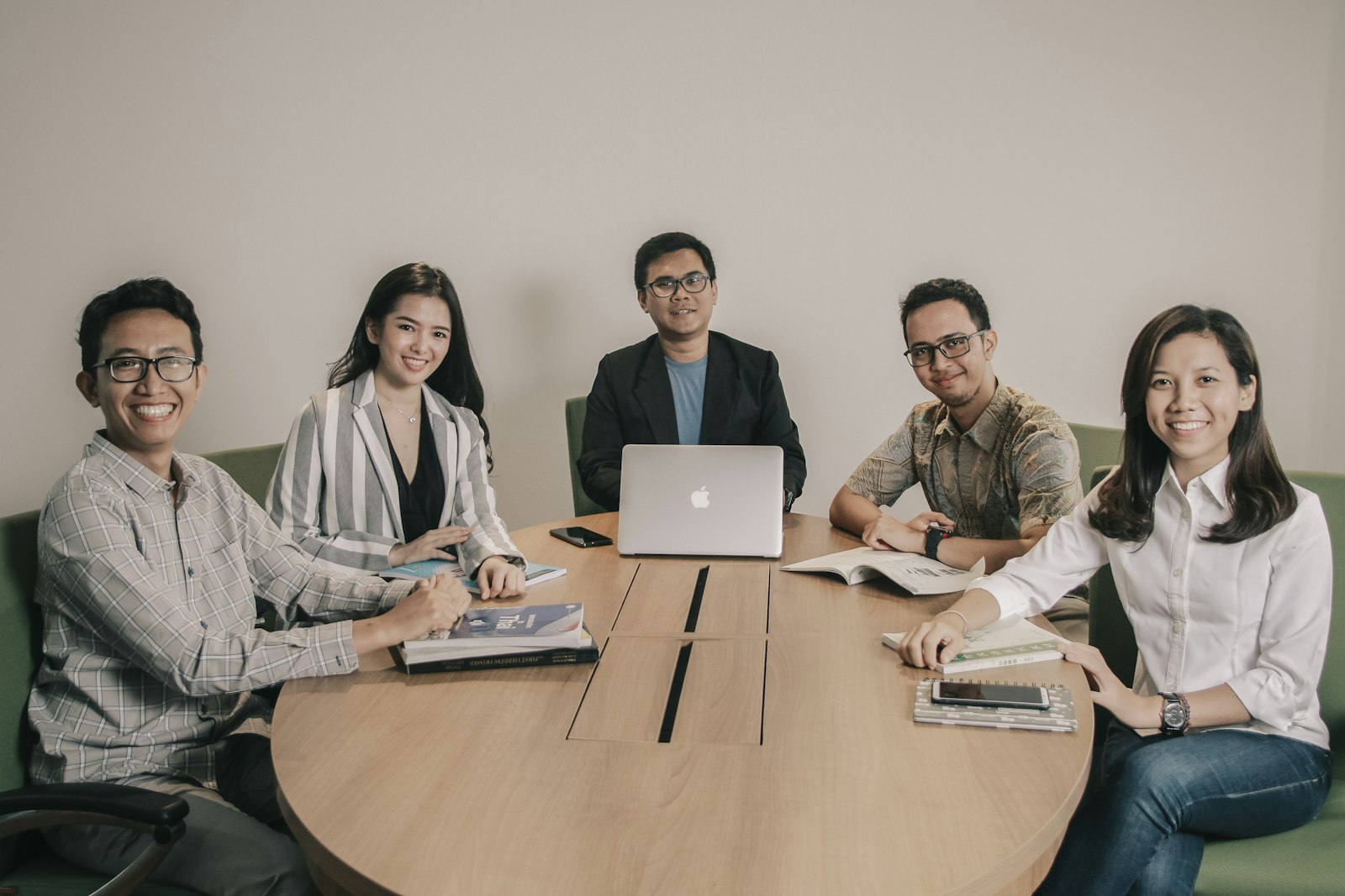Outsourced team of five professionals meeting around a table