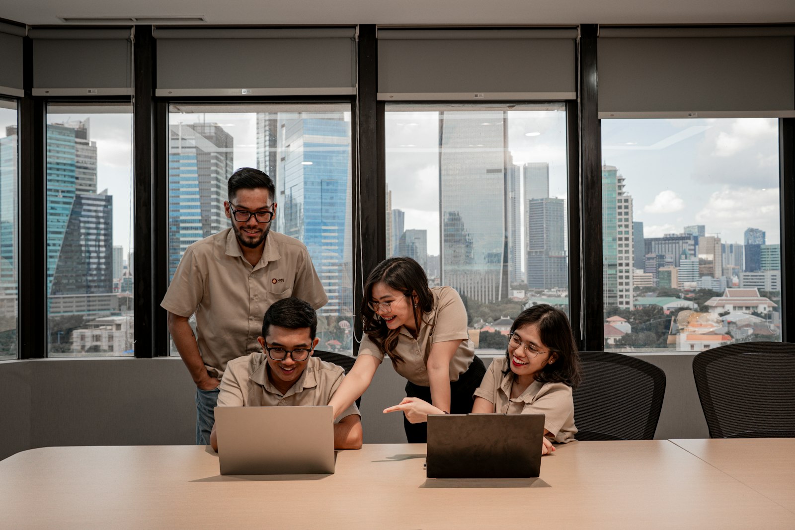 Home Outsourcing team collaborating on laptops in a modern office